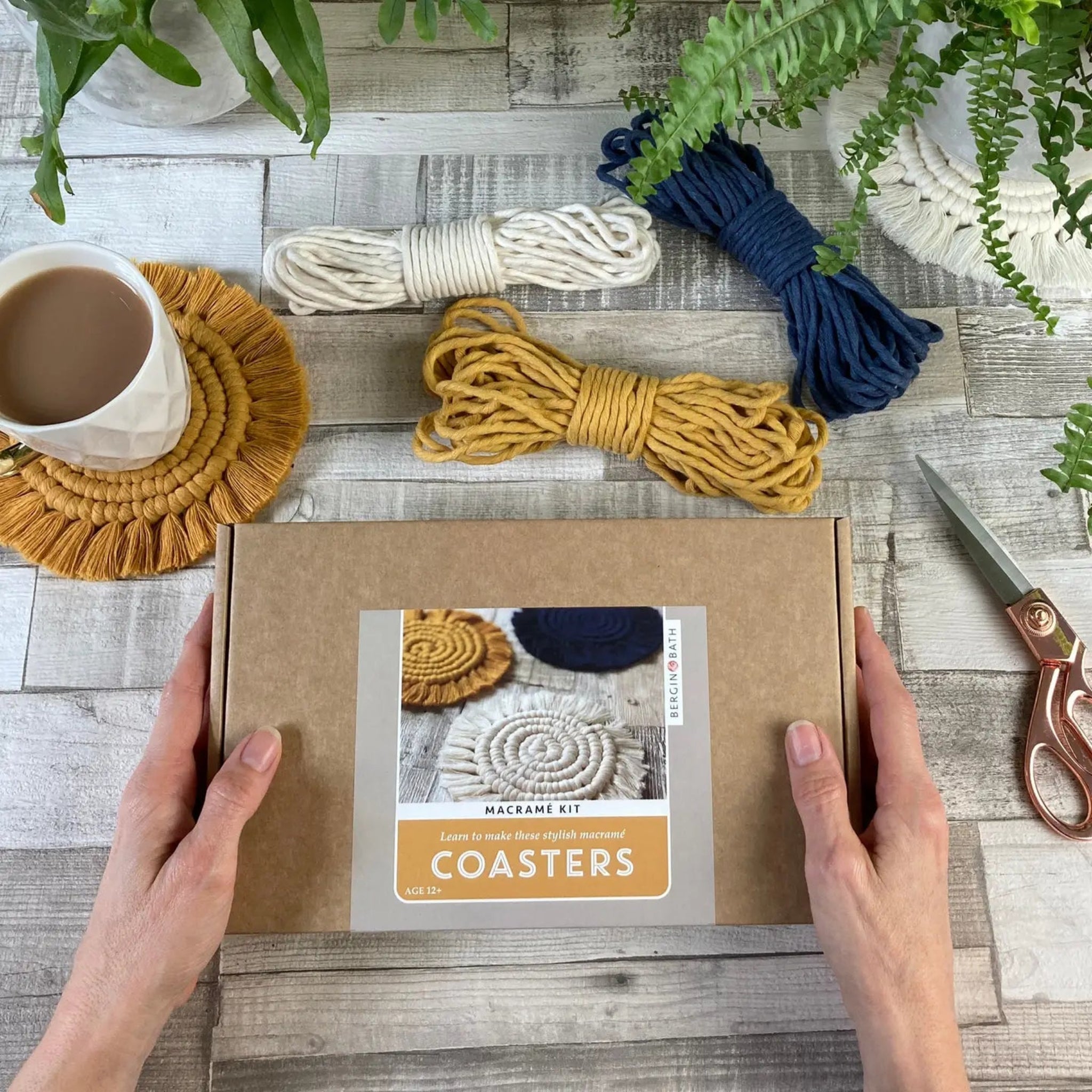 Macrame coaster kit with materials on a wooden surface